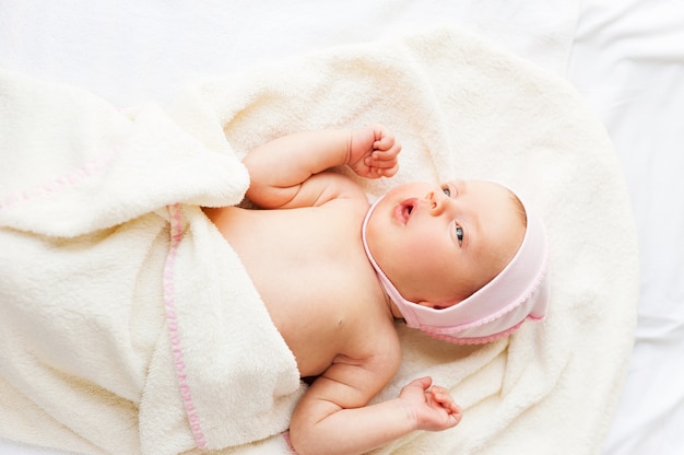 Lei è così carina! Vista dall'alto del piccolo bambino sdraiato a letto e guardando lontano