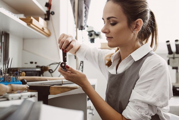 Lei sa cosa sta facendo vista laterale del giovane gioielliere femminile che prepara gli strumenti per