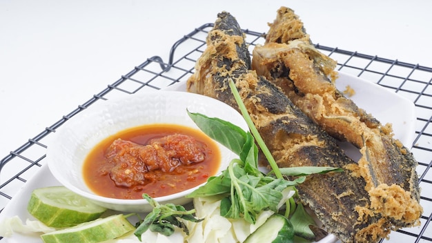 Lele Goreng Il pesce gatto fritto è pronto da mangiare Pesce gatto fritto sul tavolo con verdure Cibo culinario tradizionale indonesiano