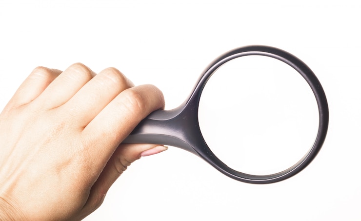 Foto lente d&#39;ingrandimento della holding della mano isolata