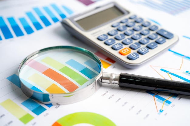 Lente d'ingrandimento e calcolatrice su grafici carta grafica Sviluppo finanziario Conto bancario Statistiche Investimento Dati di ricerca analitica Economia Borsa valori Concetto di ufficio commerciale