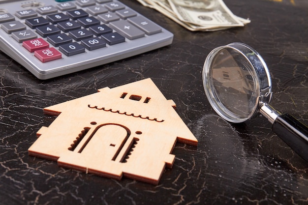 Lente d'ingrandimento e silhouette di casa in legno