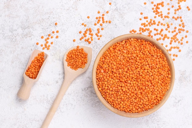 Lenticchie rosse in piatto di legno e cucchiaio su sfondo di pietra bianca Super cibo vegetariano Vista dall'alto Piatto lay