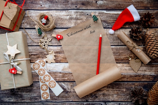 Lettera a babbo natale, lista dei desideri di natale su fondo di legno tra decorazioni per le vacanze