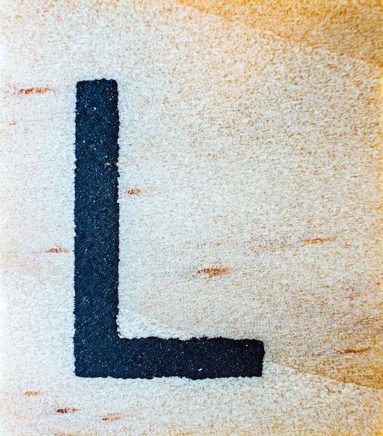 Lettera L incisa al laser su macro dettaglio texture ravvicinata in legno di balsa