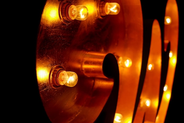 Lettera per il segno con le lampadine Lettera W su una lampadina gialla e sfondo nero