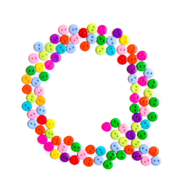 Lettera Q dell'alfabeto inglese da un gruppo di piccoli pulsanti colorati su fondo bianco