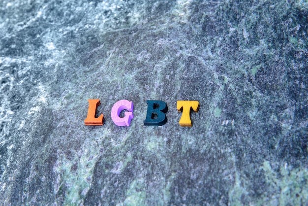 lettere colorate in legno LGBT su uno sfondo di marmo blu