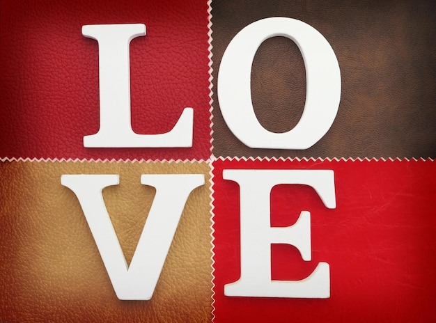 Lettere di legno che formano la parola amore scritto su fondo in pelle