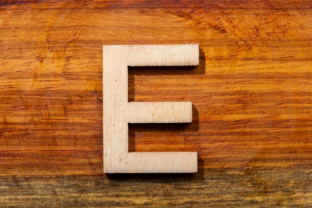 Lettere di legno E su fondo di legno