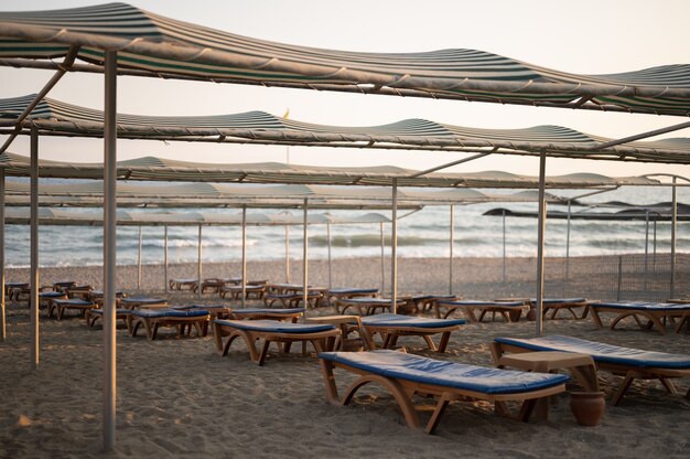 Lettini con ombrellone in spiaggia. Industria del turismo. Foto di alta qualità