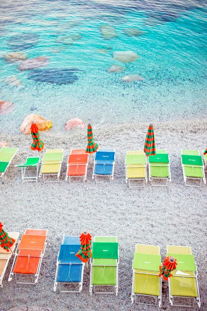 Lettini ed ombrelloni alla bella spiaggia europea a Monterosso in Italia, Cinque Terre, Liguria