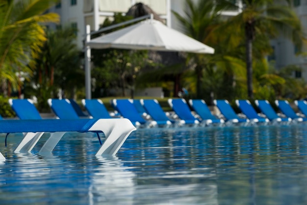 Lettini intorno alla piscina in un resort per vacanze al mare