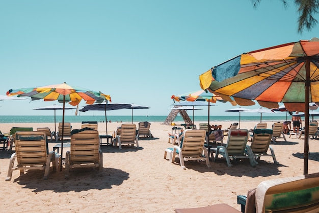 Lettini sulla spiaggia tropicale con cielo calmo. vista mare e spiaggia di sabbia, sfondo estivo.