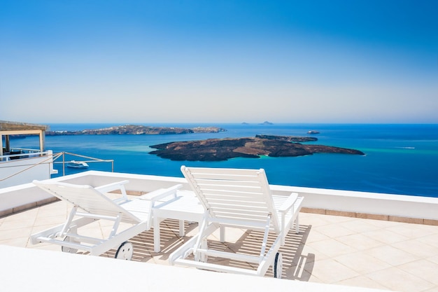 Lettini sulla terrazza di un hotel di lusso. Isola di Santorini, Grecia. Bellissimo paesaggio estivo con vista sul mare