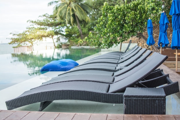 Lettino in rattan accanto alla piscina dell'hotel