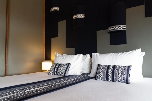 Letto bianco moderno e combinazione di cuscini blu scuro di camera da letto in legno vintage in stile asiatico