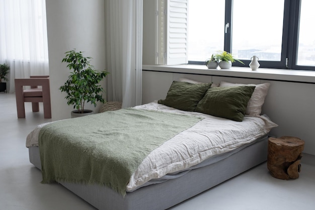 Letto matrimoniale con cuscini nei colori bianco e verde treetop e plaid grigio