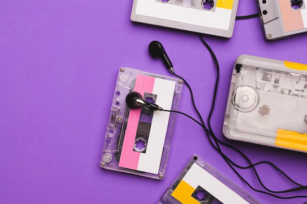 Lettore di cassette con auricolari e cassette su sfondo viola