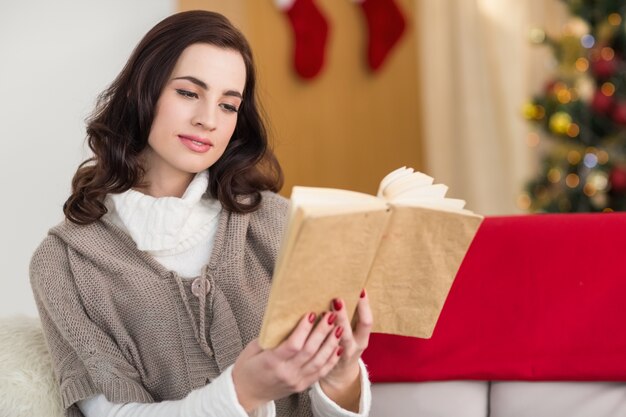 Lettura rilassata del brunette sullo strato a natale