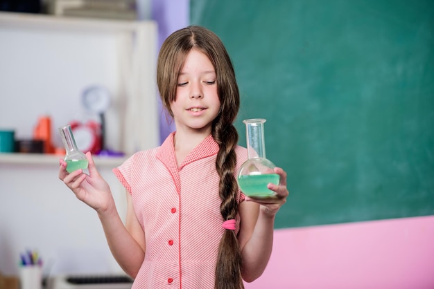 Lezione affascinante Reazione chimica Liquido chimico Lezione di scienza Laboratorio scolastico Bambina con tubo chimico Educazione biologica Ragazza classe chimica provetta Esperimento scientifico