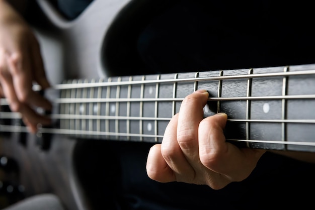 Lezione di primo piano della mano del bassista e tema di pratica Riproduzione di musica dal vivo per chitarra elettrica basso e concetto di abilità