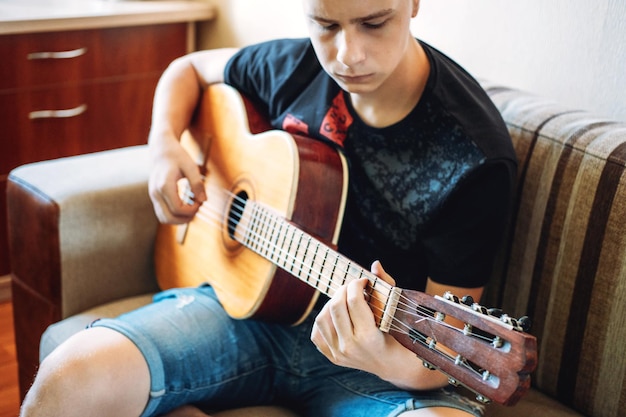 Lezioni di chitarra per principianti adolescenti caucasici che suonano la chitarra con lezioni di chitarra online che si divertono