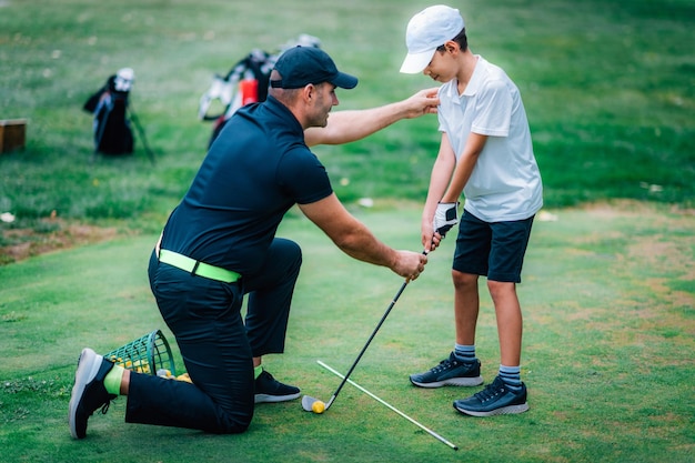 Lezioni di golf Istruttore di golf che dà lezione di gioco a un giovane ragazzo