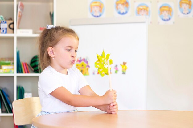 Lezioni di sviluppo e logopedia con una bambina. Logopedia e giochi di spinning. ragazza che soffia