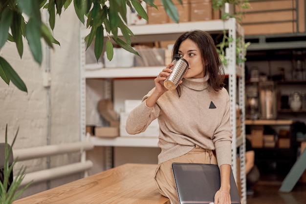 Libero professionista appoggiato al tavolo e bevendo caffè