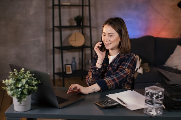 Libero professionista asiatico della ragazza che lavora ad un computer portatile