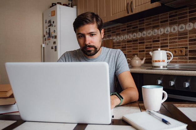 Libero professionista del giovane che usa il computer portatile che studia online o che lavora