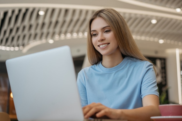 Libero professionista donna che utilizza laptop, guarda corsi di formazione online, lavora a casa. Blogger di successo in live streaming