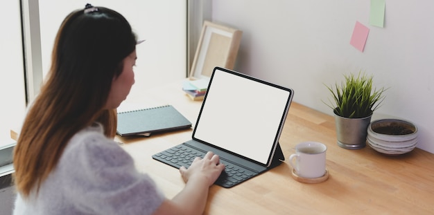 Libero professionista femmina giovane che lavora al suo progetto con tablet