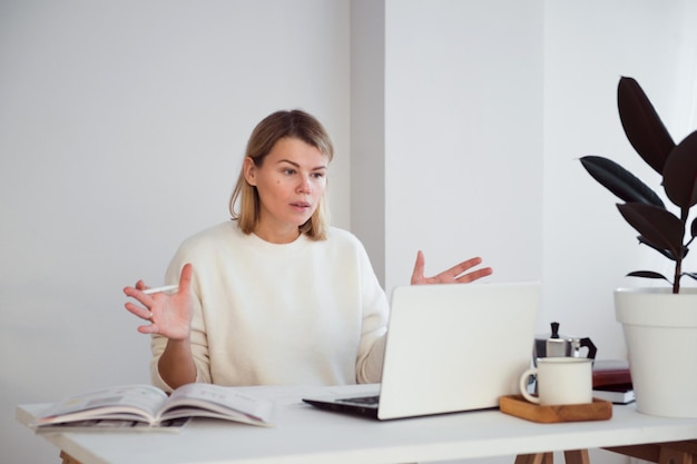 libero professionista femminile online che lavora al tavolo utilizzando il computer