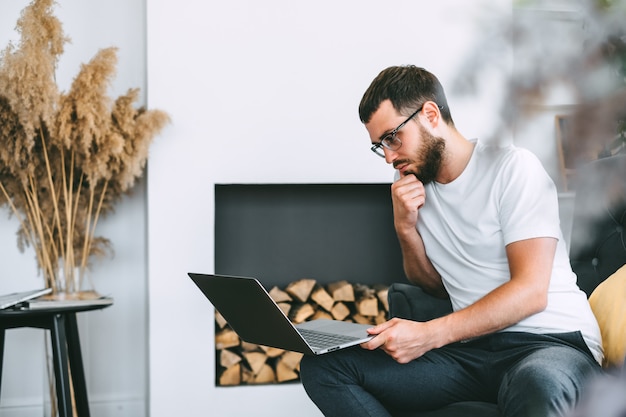 Libero professionista giovane uomo caucasico utilizzando il computer portatile