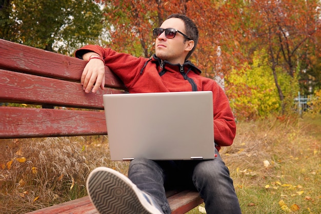 Libero professionista in autunno Park. Redattore della rivista che revisiona il nuovo articolo ricevuto via e-mail. uomo che naviga sul web su un laptop connesso al wifi. Studente che si prepara per gli esami all'aperto utilizzando un computer portatile.