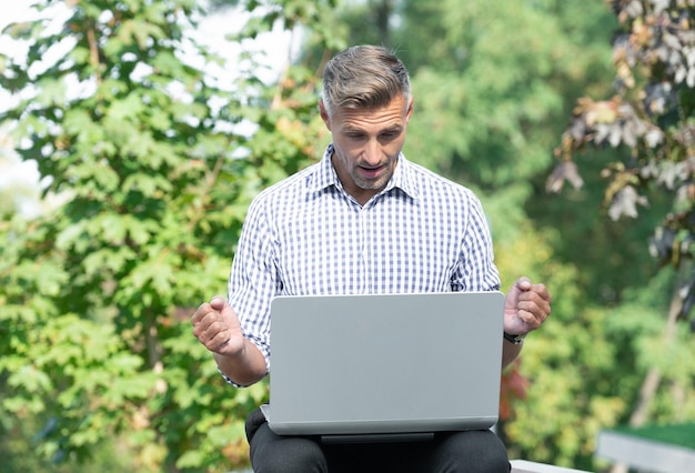 Libero professionista stupito che lavora al computer portatile libero professionista all'aperto di affari dell'uomo del computer portatile con il pc