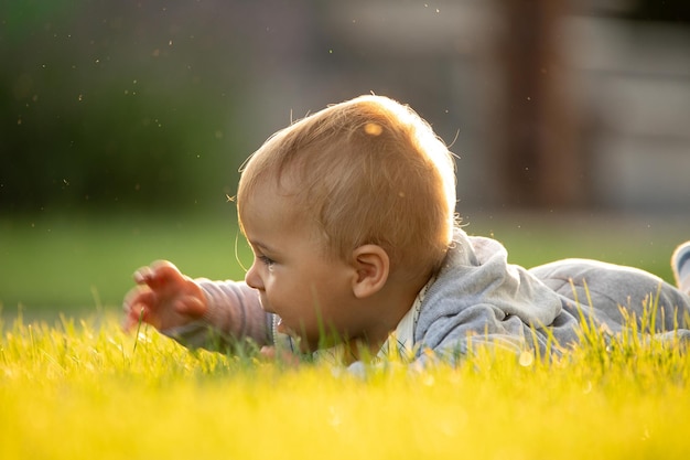 Libertà di ricreazione e concetto di infanzia Bambino felice all'aperto che si gode la calda giornata estiva sul prato verde nel cortile del cottage