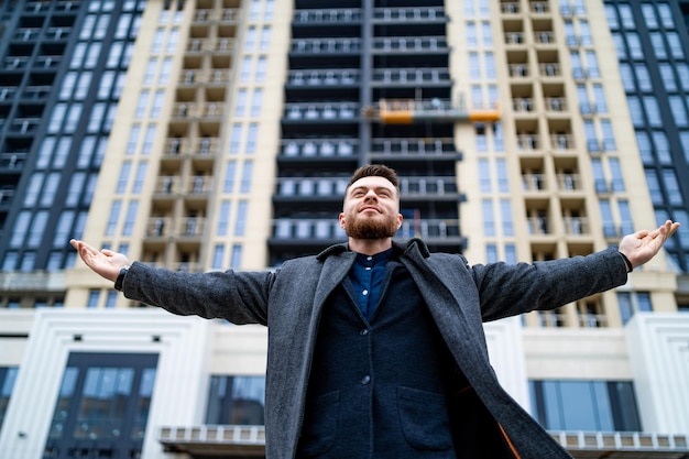 Libertà L'uomo fiducioso allargò le braccia bianche camminando per strada Giovane turista che guarda nella città moderna Imprenditore di successo che rimane per strada