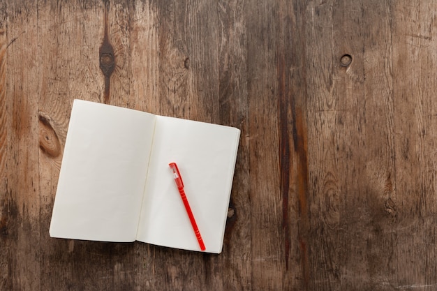 Libretto bianco sul tavolo in legno con una penna