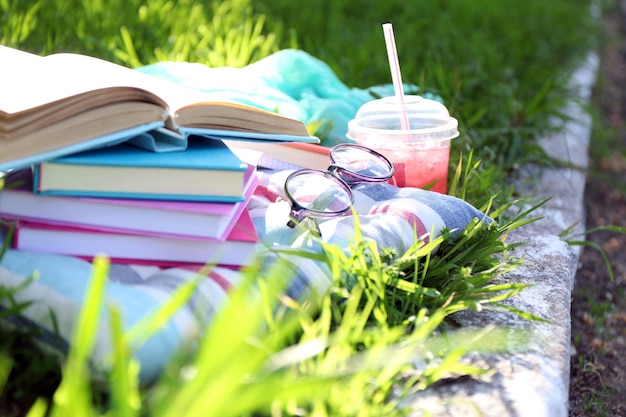 Libri bicchieri e drink sul primo piano dell'erba