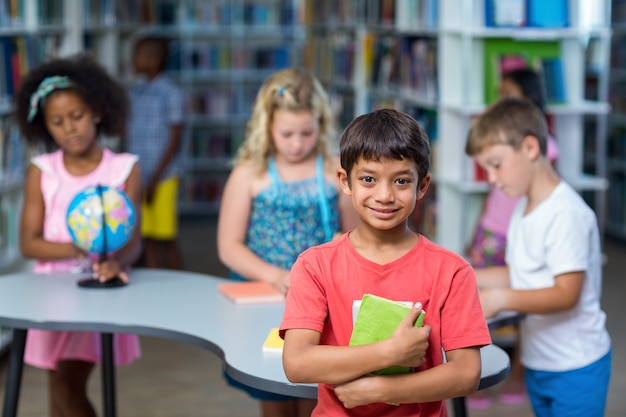 Libri della tenuta del ragazzo contro i compagni di classe