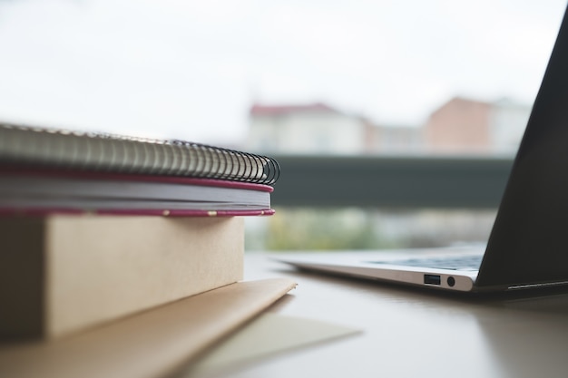 Libri di istruzione a distanza taccuini e laptop sul tavolo e mano dell'uomo che tiene soldi