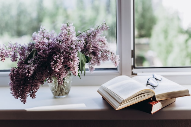 Libri e vaso vintage con lillà in fiore primaverile