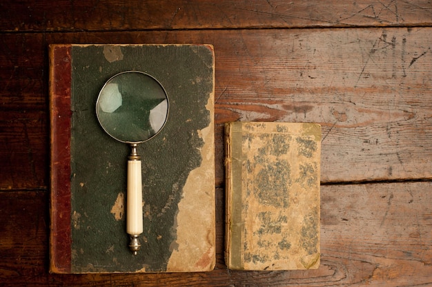 libri vintage con lente d'ingrandimento ottica sul vecchio tavolo di legno