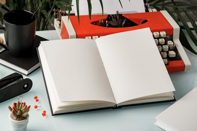 Libro a copertina rigida e macchina da scrivere d'epoca su scrivania bianca