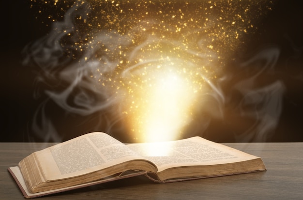 Libro antico aperto su una scrivania di legno