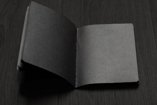 Libro aperto con foglio nero sul tavolo di legno
