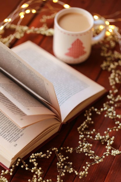 Libro aperto con tazza di Natale e ornamenti